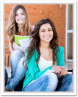 Two students sitting in front of entrance steps